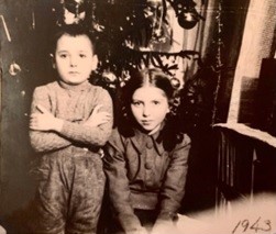 Ricardo Mayerson, junto a otra niña judía, en un refugio, (árbol de navidad atrás). Polonia, 1943.