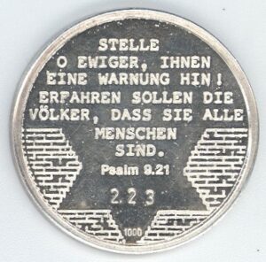 Reverso de moneda conmemorativa entregada a Grete Schmitz, en la ciudad de Bonn (Alemania), cuando fue invitada por el gobierno aleman, en 1988. "¡Te pongo en advertencia! La gente debería recordar, que todos somos seres humanos" Salmo 9:21 (Traducción del texto grabado en la moneda).