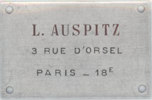 Placa identificatoria ubicada fuera de la tienda de mueblería y decoración de Ladislao Auspitz. París, Francia.